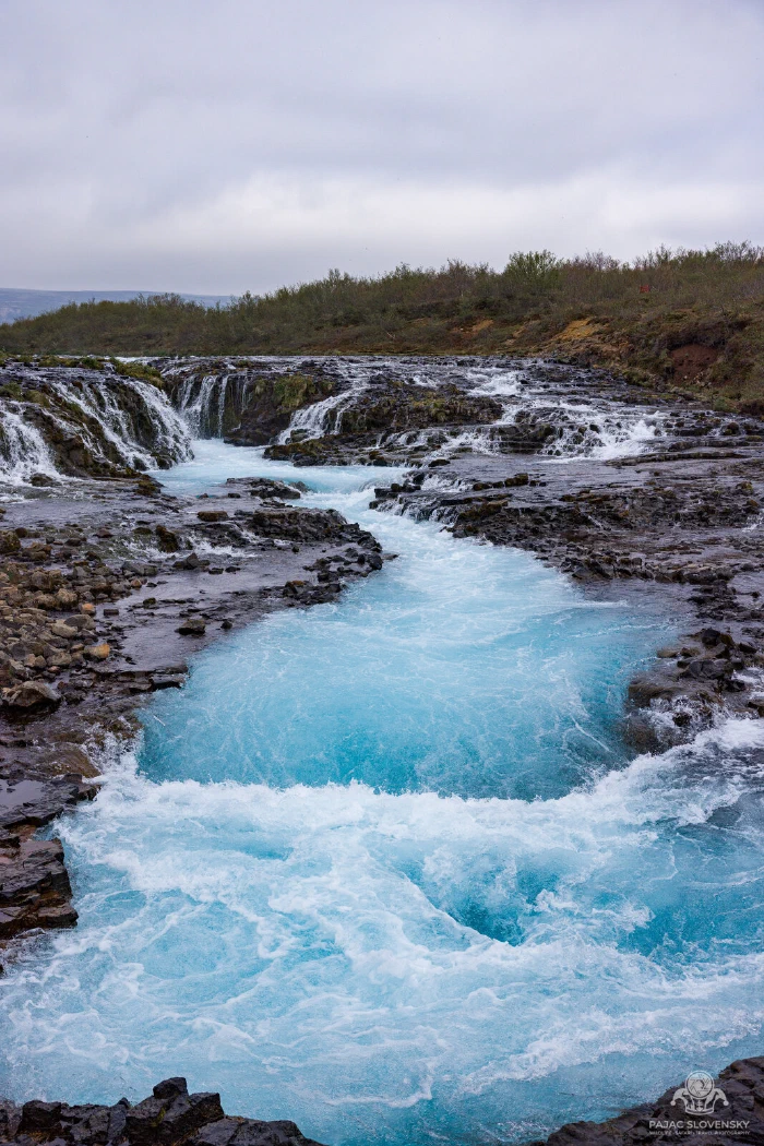 Electric-blue glacial water rushing through the Brúarfoss chute