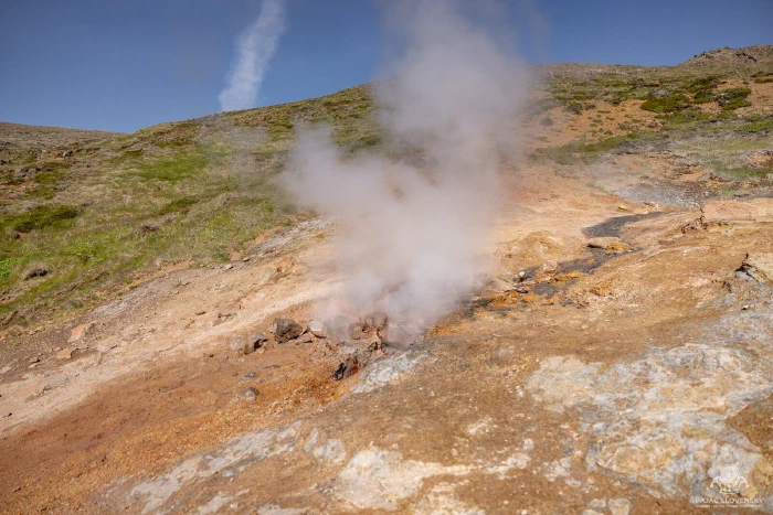 Fumarole steam venting from an ochre geothermal hillside