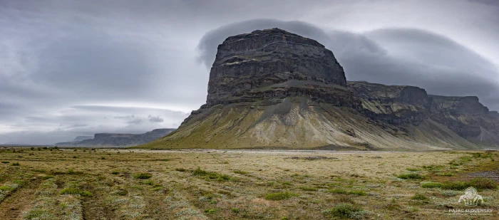 Lómagnúpur promontory capped by sweeping lenticular cloud above mossy plain