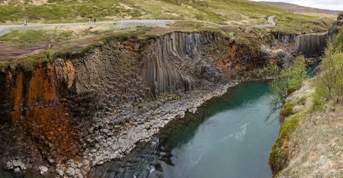 Curving basalt columns of Studlagil Canyon above the milky teal Jokla river