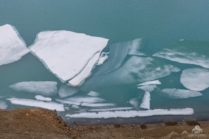 Rafts of white ice drifting on Víti's milky turquoise lake