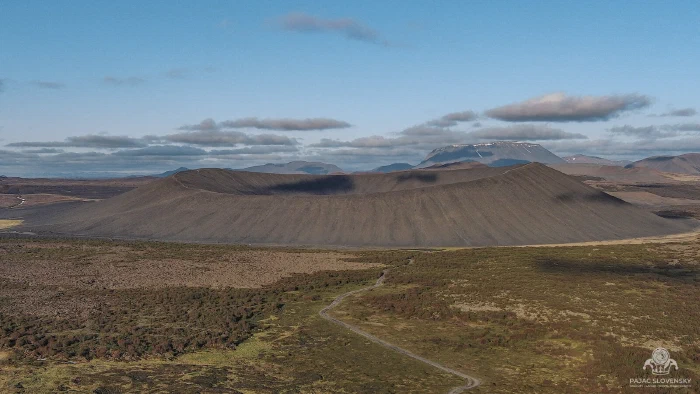 Hverfjall's vast grey tephra crater ring rising above mossy plain