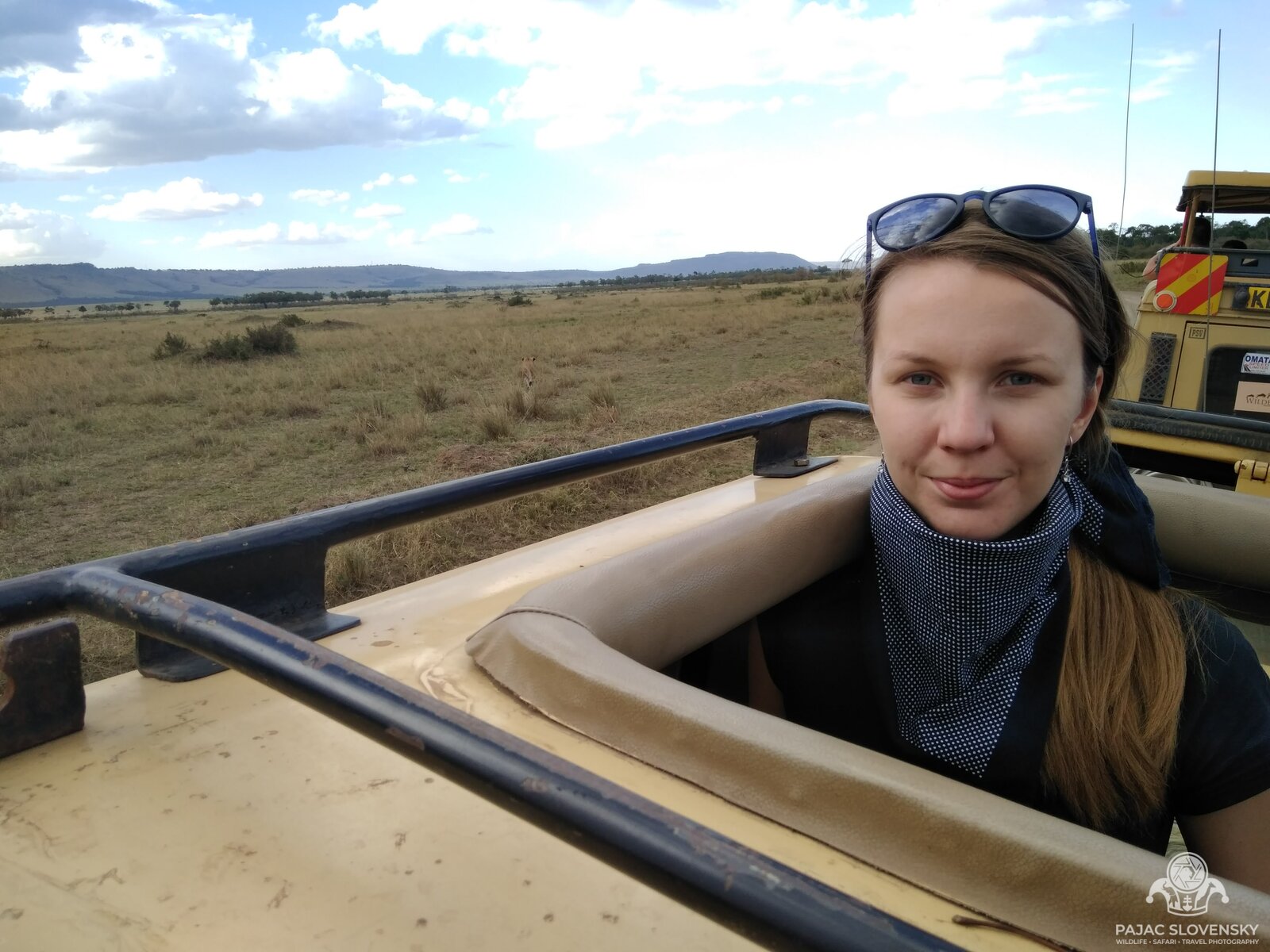 Riding in the open roof hatch of the safari truck above the Mara plains
