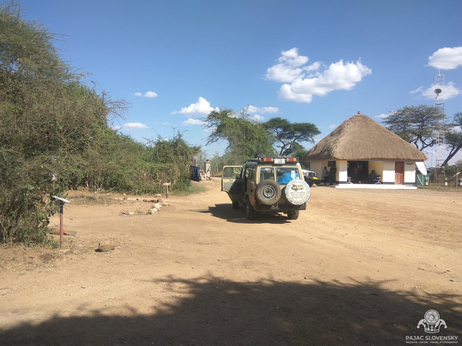 The thatched Serengeti park gate post, with the safari truck waiting in the sun