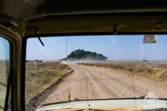 The track ahead from the safari vehicle, a kopje on the horizon