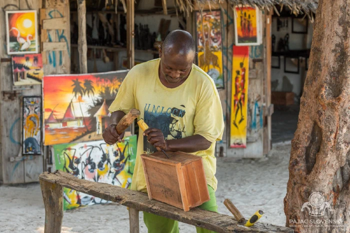 The carpenter's bench with Tingatinga paintings hung as a back wall