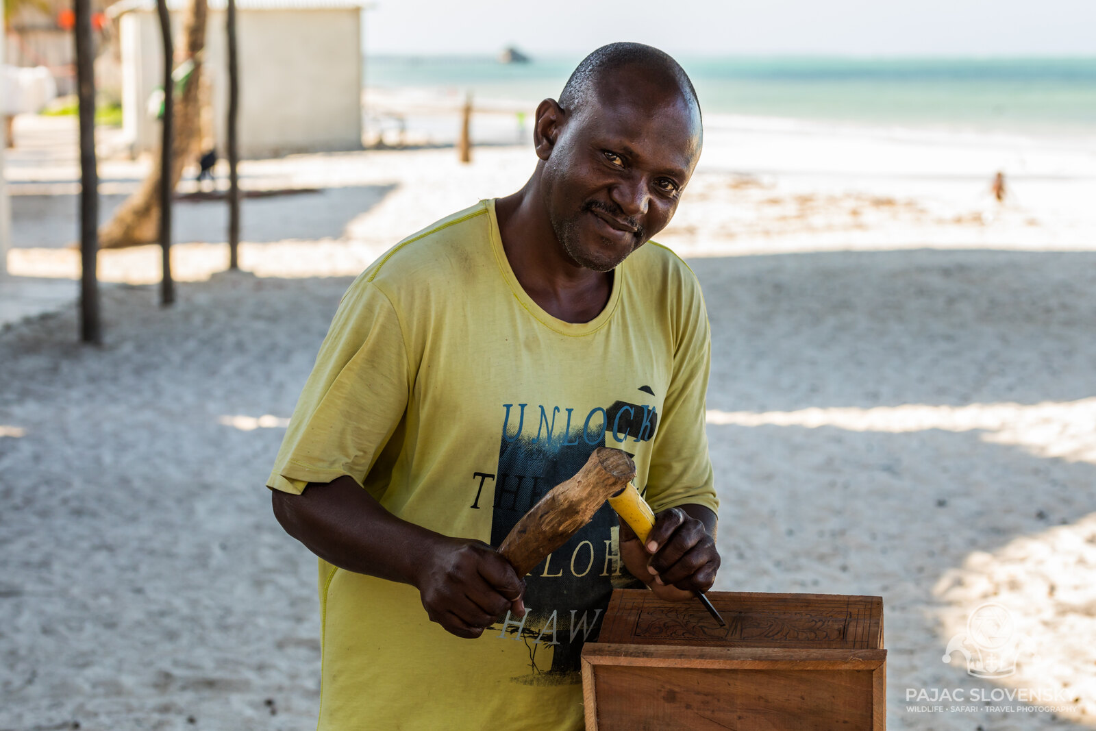 The carpenter's open-air workshop on Kiwengwa beach, sea beyond the stall