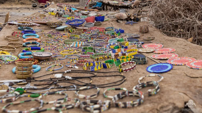 Handmade beadwork jewelry spread across a long table in the village