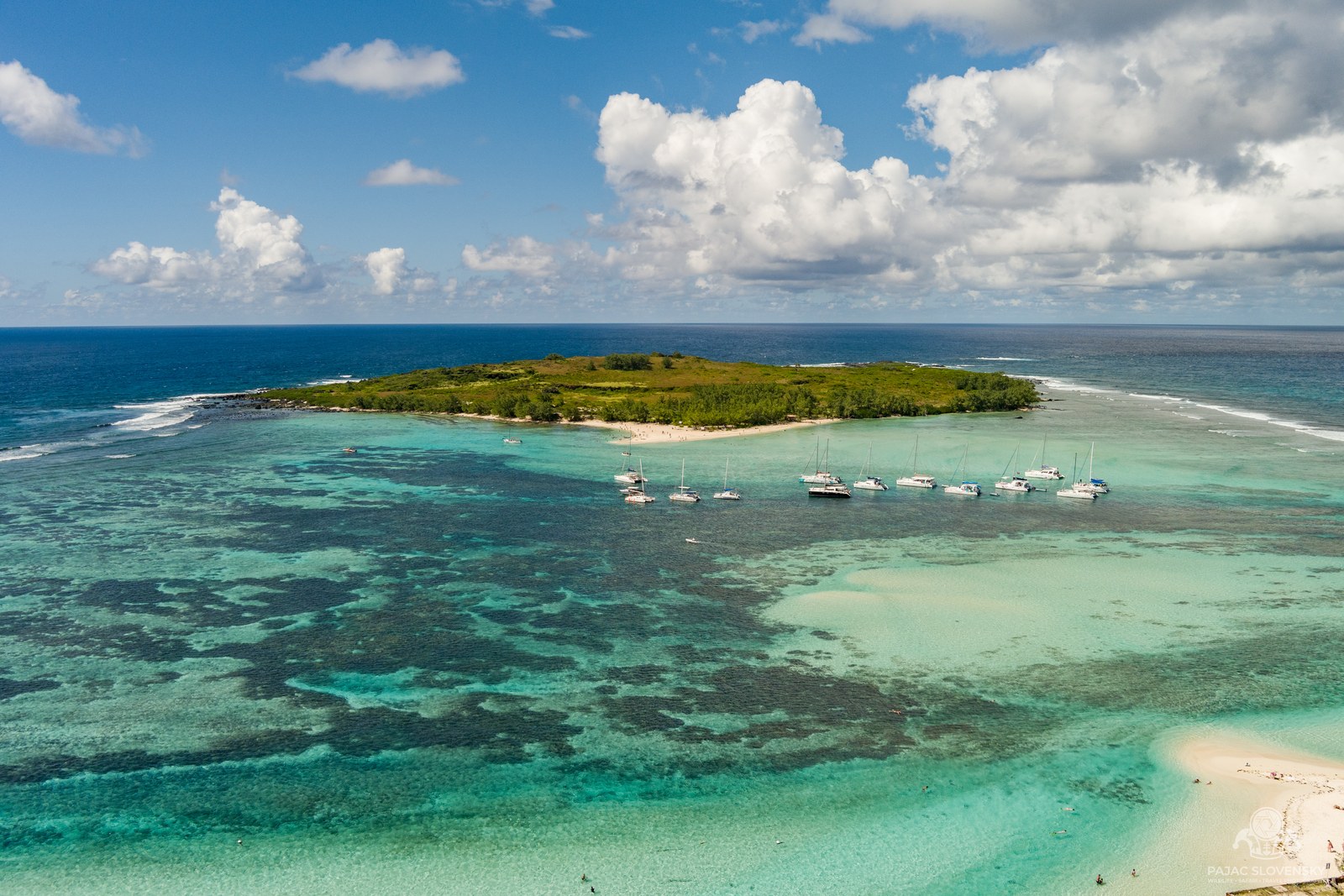 Gabriel Island anchorage with a line of catamarans inside the turquoise reef