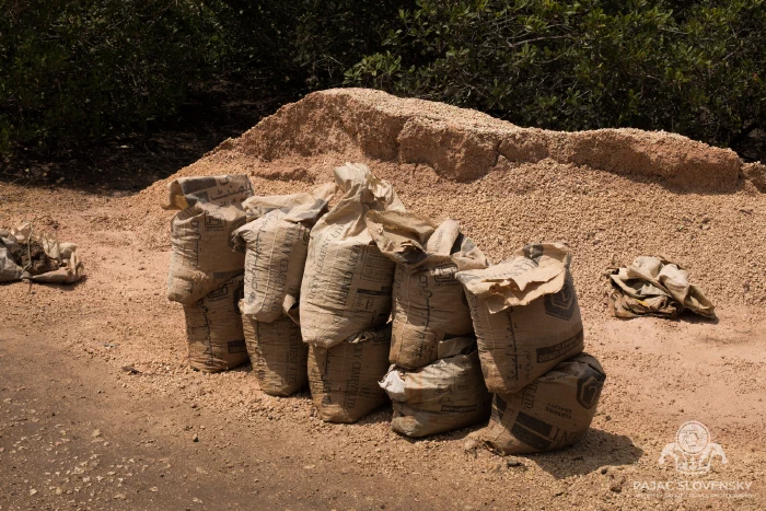 Sacks of charcoal waiting for a buyer beside the track