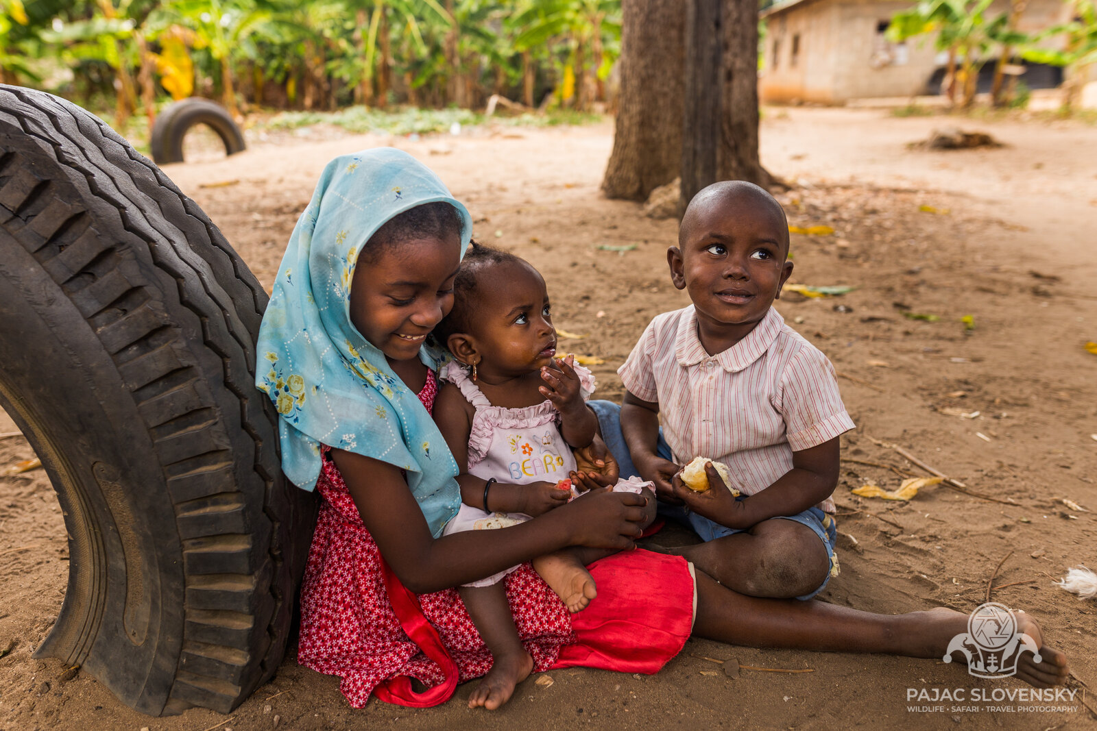 Three children sharing a tractor tyre for a reading nook