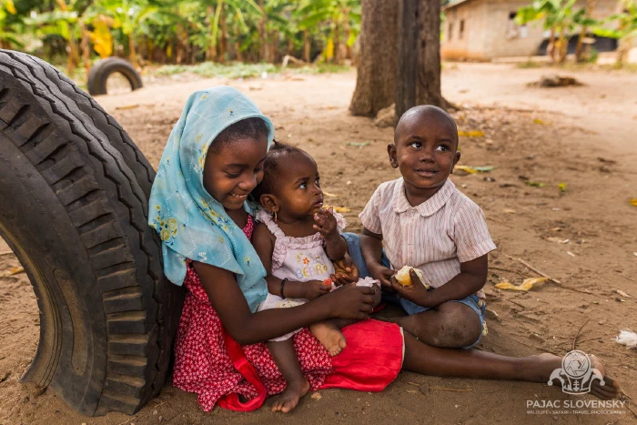 Three children sharing a tractor tyre for a reading nook