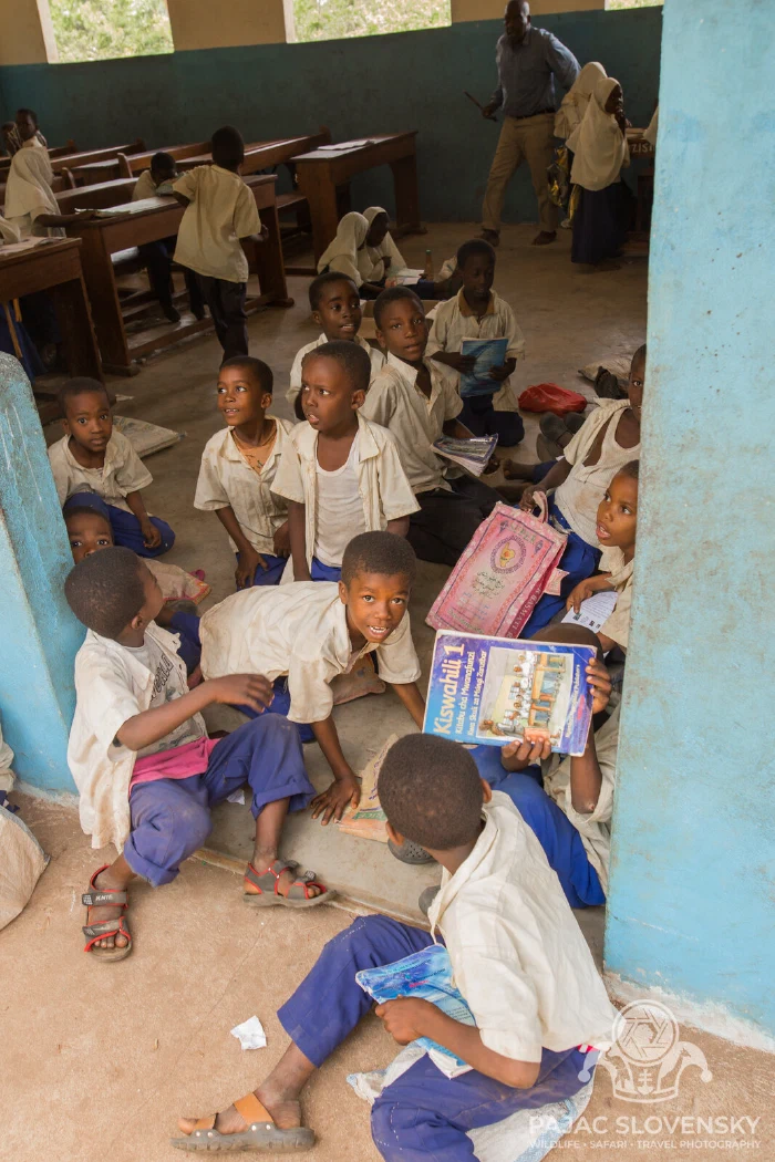 Pupils crowding the light of the classroom windows