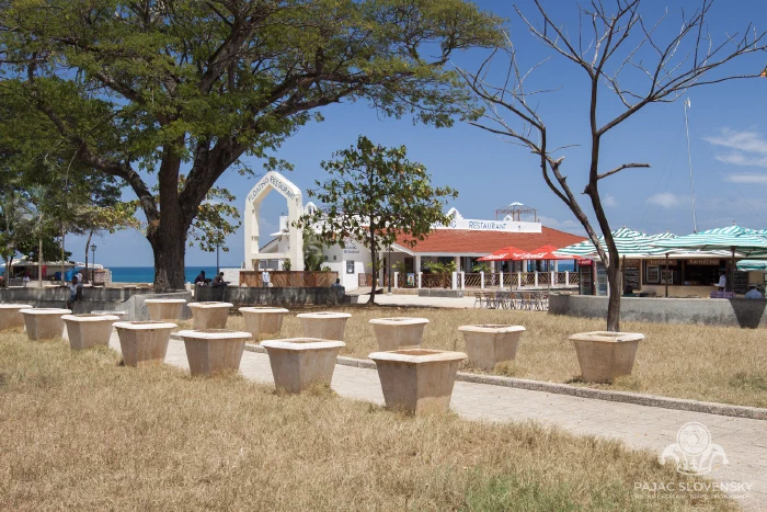 A colonial-era building behind its seafront lawn