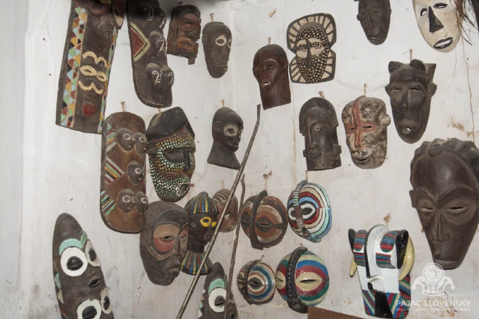 Masks and carvings crowding a curio-shop display