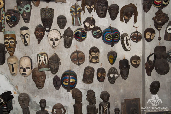 Carved wooden masks covering a curio-shop wall